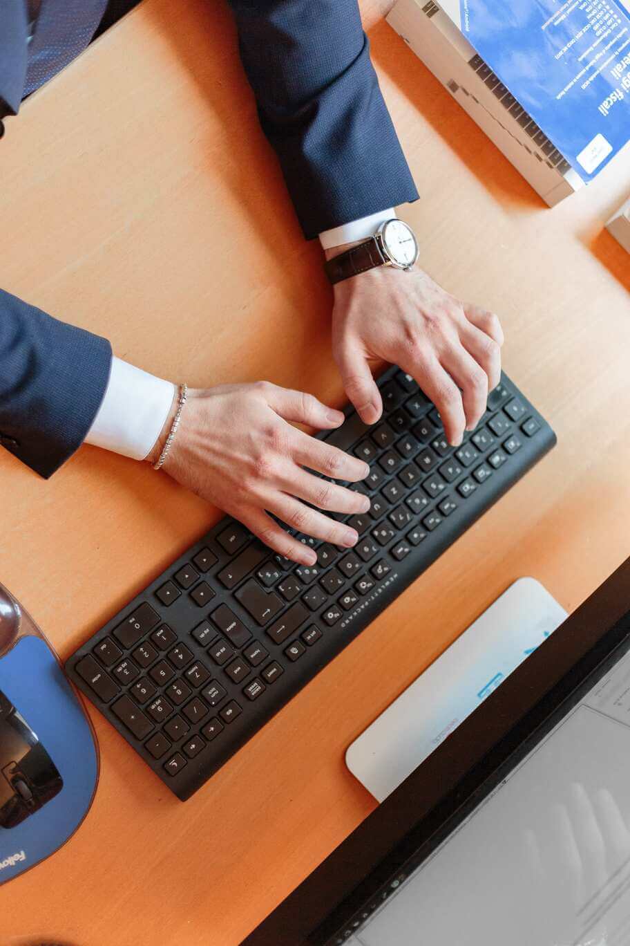 Image d'un homme en costume écrivant un clavier sur un bureau